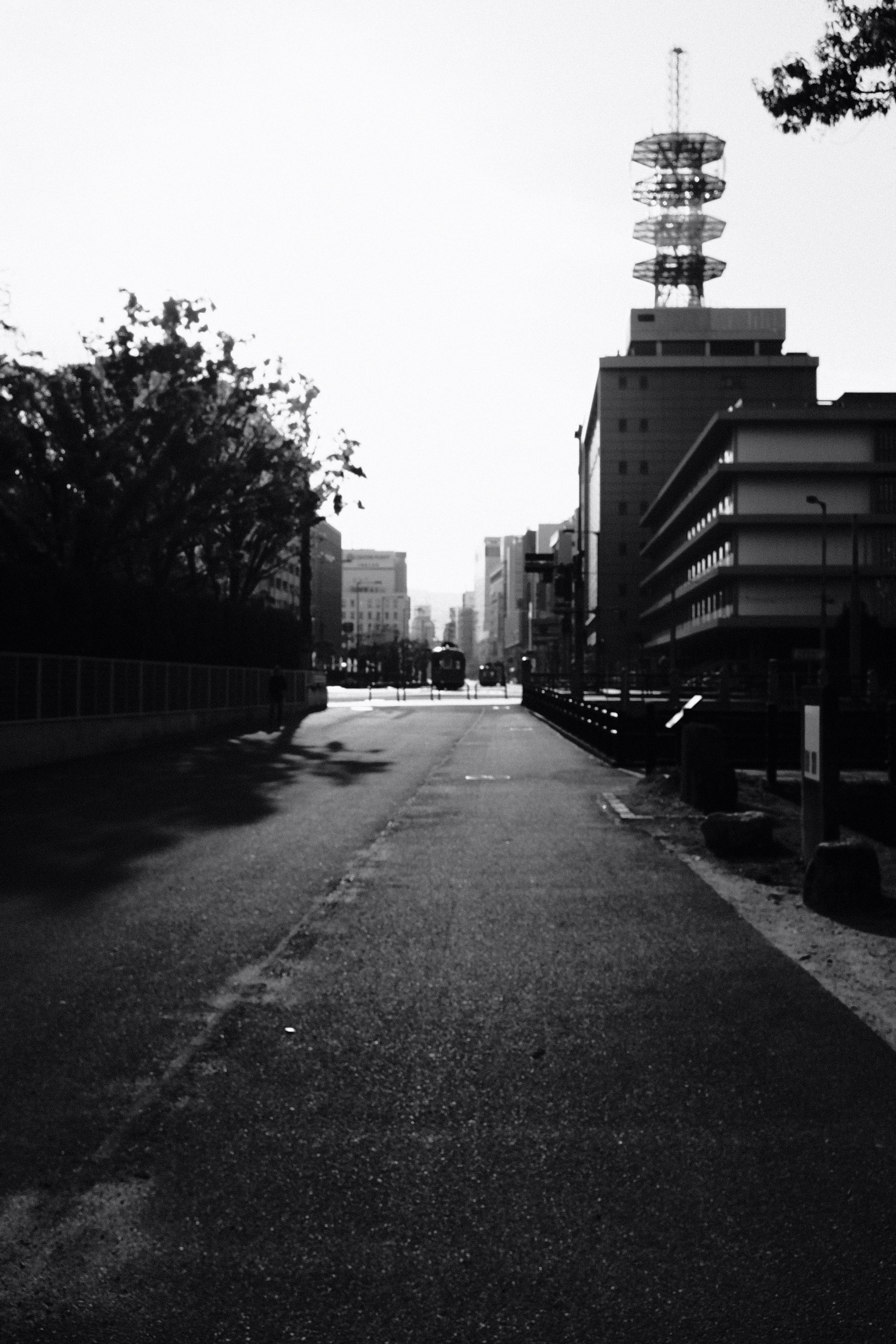 grayscale photo of a road in the middle of a city